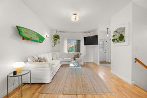 a living room with a white couch and a tv at Stylish 3-Bedroom Home in Buena Vista in Saskatoon