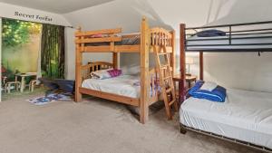 Alpine Serenity by AvantStay Beach Lake Access Theater Deck Playroom في Albrightsville: غرفة نوم مع سريرين بطابقين ومكتب