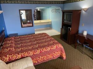 Vip Inn Motel في Cudahy: غرفة فندق مع سرير وتلفزيون