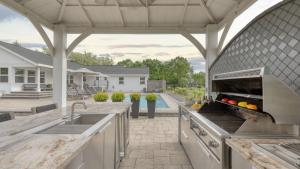 an outdoor kitchen with a grill and an outdoor kitchen at Chic Sonoma Oasis w Pool Bocce Hot Tub Minutes to Downtown in Sonoma