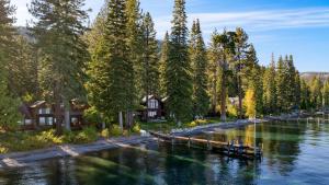 Un río con casas y árboles y un muelle. en Homewood Lakefront by AvantStay Private Beach Lake Access Views, en Homewood