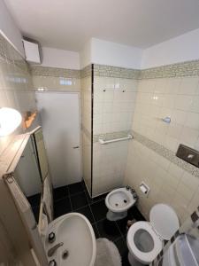 a bathroom with two toilets and a sink and a shower at Depto 1 ambiente frente al mar y céntrico in Mar del Plata