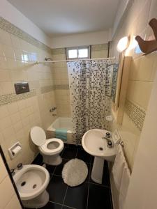 a bathroom with two toilets and a sink and a shower at Depto 1 ambiente frente al mar y céntrico in Mar del Plata