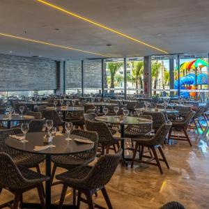 ein Restaurant mit Tischen und Stühlen und ein Spielplatz in der Unterkunft Salinas Resort Premium in Salinópolis