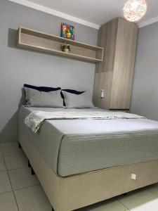 a bedroom with a large bed with a shelf on the wall at Apartamento á 5 minutos do centro in Garanhuns