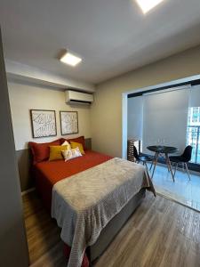 a bedroom with a bed and a table and a window at Studio Metrô Tucuruvi in São Paulo