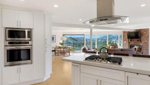 Designer Retreat w Pool Firepits Panoramic Views The Lake House at Malibu في أغورا هيلز: مطبخ مع موقد فرن علوي بجوار غرفة المعيشة
