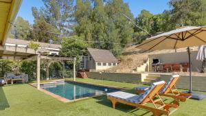 Designer Retreat w Pool Firepits Panoramic Views The Lake House at Malibu في أغورا هيلز: حمام سباحة مع كرسيين ومظلة