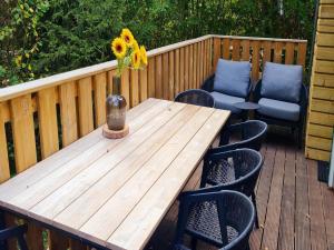 uma mesa de madeira com um vaso de flores num deque em Tranquil Countryside Stay in Durbuy em Septon