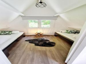 um quarto no sótão com 2 camas e um tapete em Tranquil Countryside Stay in Durbuy em Septon