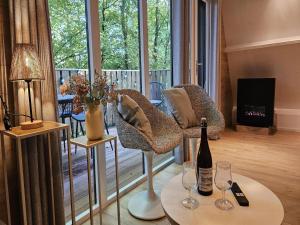 Una sala de estar con un sofá y una mesa con copas de vino. en Comfortable Chalet near Durbuy Center, en Septon