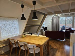 uma sala de jantar e sala de estar com mesa e cadeiras em Warm Countryside Haven in Durbuy em Septon mais 5 fotografias