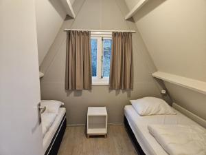 duas camas em um pequeno quarto com janela em Warm Countryside Haven in Durbuy em Septon