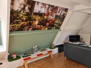uma sala de estar com um sofá e uma pintura na parede em Quiet Family Chalet in Durbuy Hills em Septon
