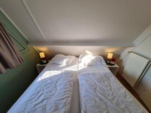 duas camas num pequeno quarto com duas lâmpadas em Quiet Family Chalet in Durbuy Hills em Septon mais 7 fotografias