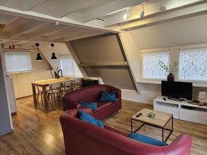 uma sala de estar com um sofá vermelho e uma mesa em Warm Countryside Haven in Durbuy em Septon