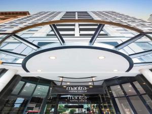 Un gran edificio con una gran lámpara de araña delante. en Mantra Sydney Central, en Sídney