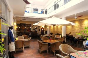a restaurant with tables and chairs and an umbrella at Hôtel La Résidence in Saint-Louis