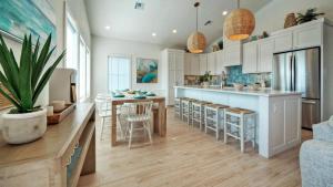 a kitchen with a island and a bar with stools at Free Heated Pool Golf Cart Zone Sea La Vie by AvantStay in Port Aransas