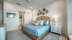 a bedroom with a bed with a blue comforter at Free Heated Pool Golf Cart Zone Sea La Vie by AvantStay in Port Aransas +44 photos