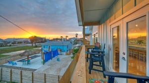 a porch of a house with chairs and a sunset at Free Heated Pool Golf Cart Zone Sea La Vie by AvantStay in Port Aransas