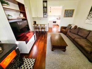 een woonkamer met een grote flatscreen-tv bij Jarrah Cottage in Waroona