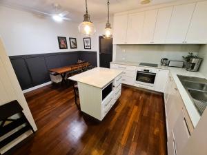 een keuken met witte kasten en een houten vloer bij Jarrah Cottage in Waroona