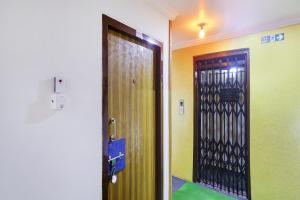 Una puerta en una habitación con suelo verde y un pasillo. en OYO 76333 Newgen Grand, en Hyderabad