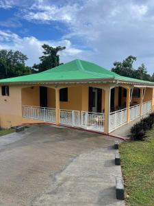 a large yellow house with a green roof at Villa Jakéna à Sainte-Rose in Sainte-Rose