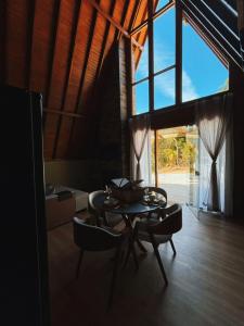 a dining room with a table and chairs in a room at Recanto do Tabuleiro chalé com hidro, lareira, churrasqueira e cozinha perto de floripa in Aguas Mornas