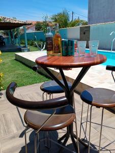 a table with drinks and glasses on a patio at Casa da Lagoa Azul in Arraial do Cabo