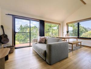 Sisters Beach Hideaway - A Coastal Escape في Sisters Beach: غرفة معيشة بها أريكة وطاولة