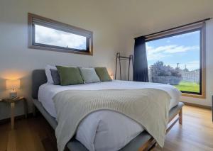 Sisters Beach Hideaway - A Coastal Escape في Sisters Beach: غرفة نوم بسرير كبير مع نافذة كبيرة +13 صورة