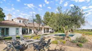 a patio with a table and chairs in front of a house at Wellsona Vineyard Retreat Pool Hot Tub Views Main Home Guest Home in Paso Robles