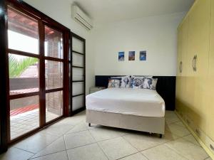 イーリャ・コンプリーダにあるCasa Triunfoのベッドと大きな窓のある寝室