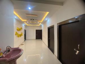 a bathroom with a purple sink and a hallway at Hotel Aurihar jn in Saidpur +1 photo