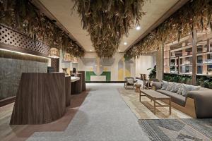 een lobby met banken, tafels en planten bij Hotel Indigo Playa del Carmen by IHG in Playa del Carmen +37 foto's