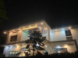 a building with a tree in front of it at night at Hotel Aurihar jn in Saidpur
