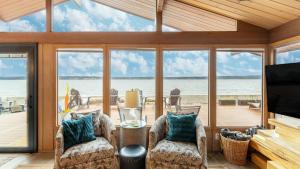 a living room with a view of the water at Oceanfront w Game Room Fire Pit Panoramic Views Angels Landing by AvantStay in Langley