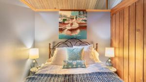 a bedroom with a bed with a painting on the wall at Oceanfront w Game Room Fire Pit Panoramic Views Angels Landing by AvantStay in Langley