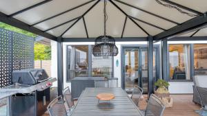 a patio with a table and chairs and a light fixture at Oceanfront w Game Room Fire Pit Panoramic Views Angels Landing by AvantStay in Langley