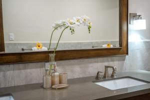 La salle de bains est pourvue d'un lavabo et d'un vase avec des fleurs. dans l'établissement Roaring River Resort, à Roaring Creek 29 autres photos