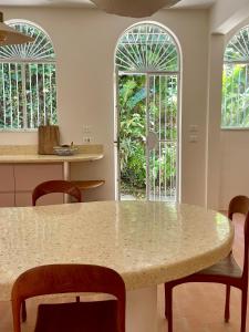 a kitchen with a table and chairs and two windows at Casa Rocha in Rio de Janeiro +32 photos