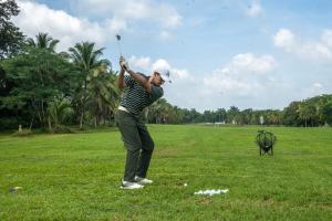Un homme balançant un club de golf dans un champ dans l'établissement Roaring River Resort, à Roaring Creek