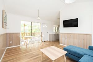 The Black Dolphin Holiday Park في ميريمبولا: غرفة معيشة مع أريكة زرقاء وطاولة