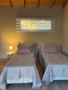 duas camas sentadas em um quarto com janela em Patagonia Nido em Trevelín