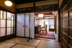 アトレチア祇園宇治別邸プレミアム في يوجي: باب مفتوح في غرفة مع طاولة