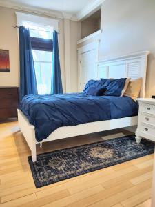 a bedroom with a bed with blue sheets and a window at Cornerstone West Lower Unit in Savannah