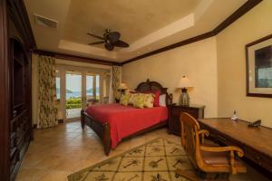 una camera da letto con un letto con un copriletto rosso di Marbella 1E 3 BR Ocean View a Isla Herradura