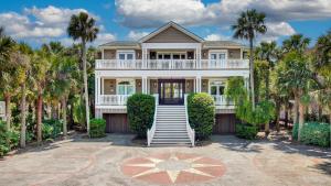 una casa con palmeras delante en 114 Ocean Boulevard by AvantStay Beachfront Infinity Pool Basketball Court Recently Renovated, en Sullivans Island